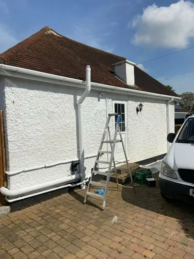 White rendered bungalow being repainted, ladders in place