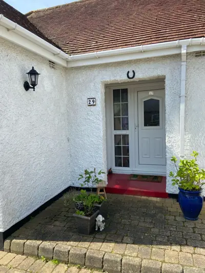 Front of a white rendered bungalow after repainting