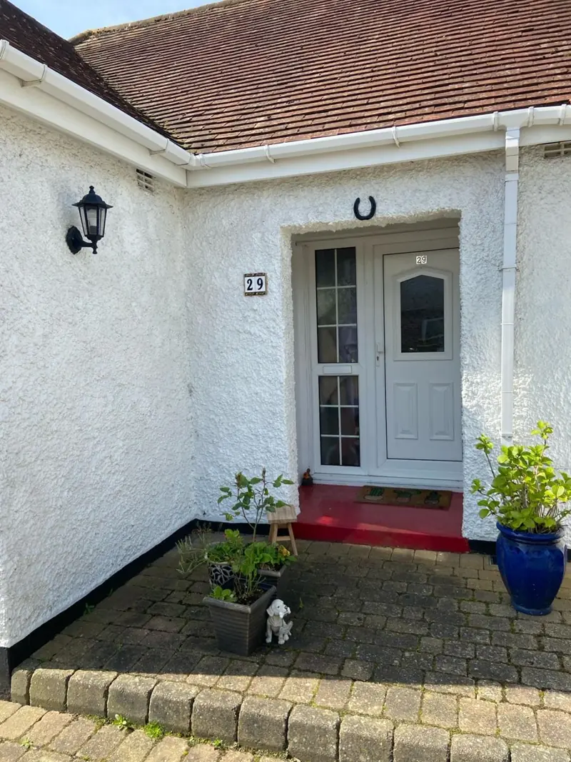 Front of a white rendered bungalow after repainting