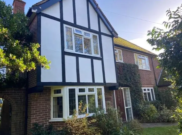 Tudor-style house with black and white exterior repainted