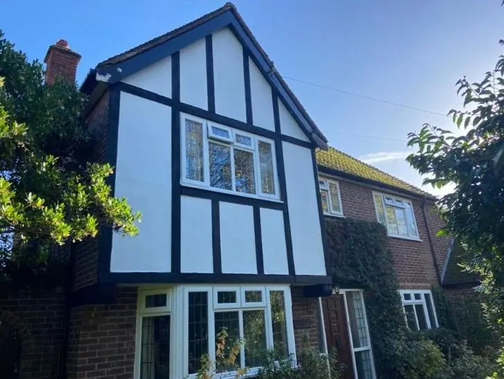 Tudor-style house with black and white exterior repainted