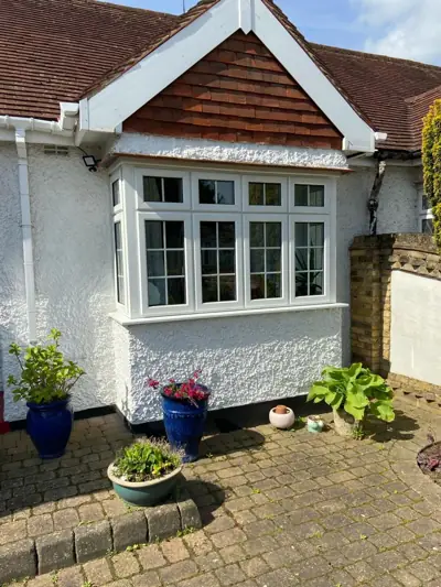 Bay-fronted bungalow with white render and windows repainted
