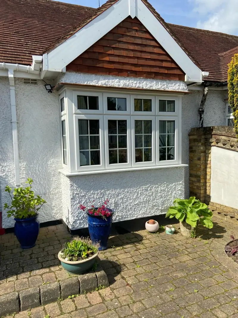 Bay-fronted bungalow with white render and windows repainted