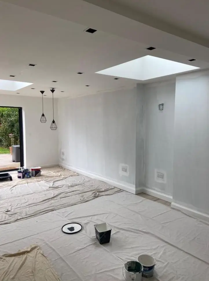 Kitchen extension walls and ceiling painted white, dust sheets covering the floor mid-job