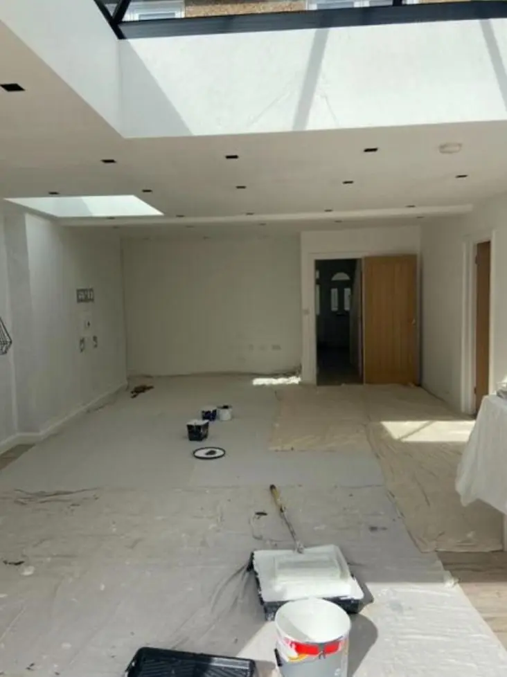 Extension looking back towards oak doors, fresh white emulsion with roller tray in the foreground