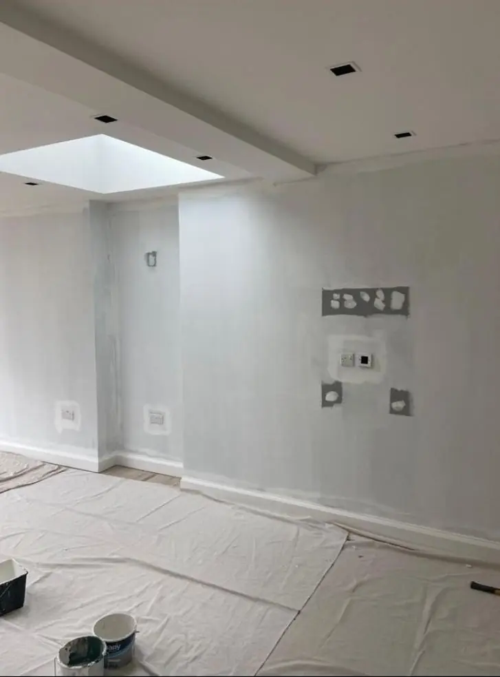 Extension wall with filler patches around sockets, prepared and partly painted white